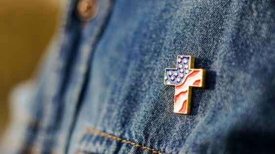 Christian cross pin on denim background