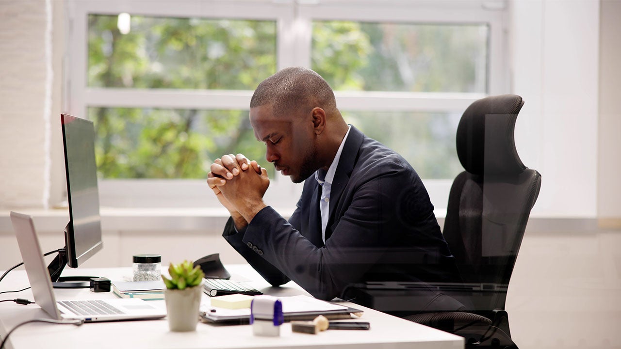 man praying at his desk